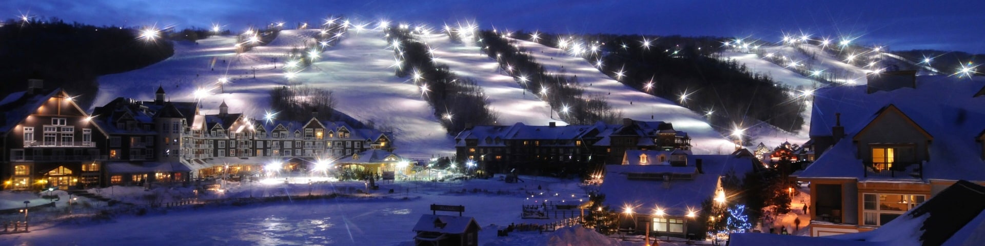 Blue Mountain Ski Resort mostrando una pequeña ciudad o aldea, escenas de noche y un hotel de lujo o resort