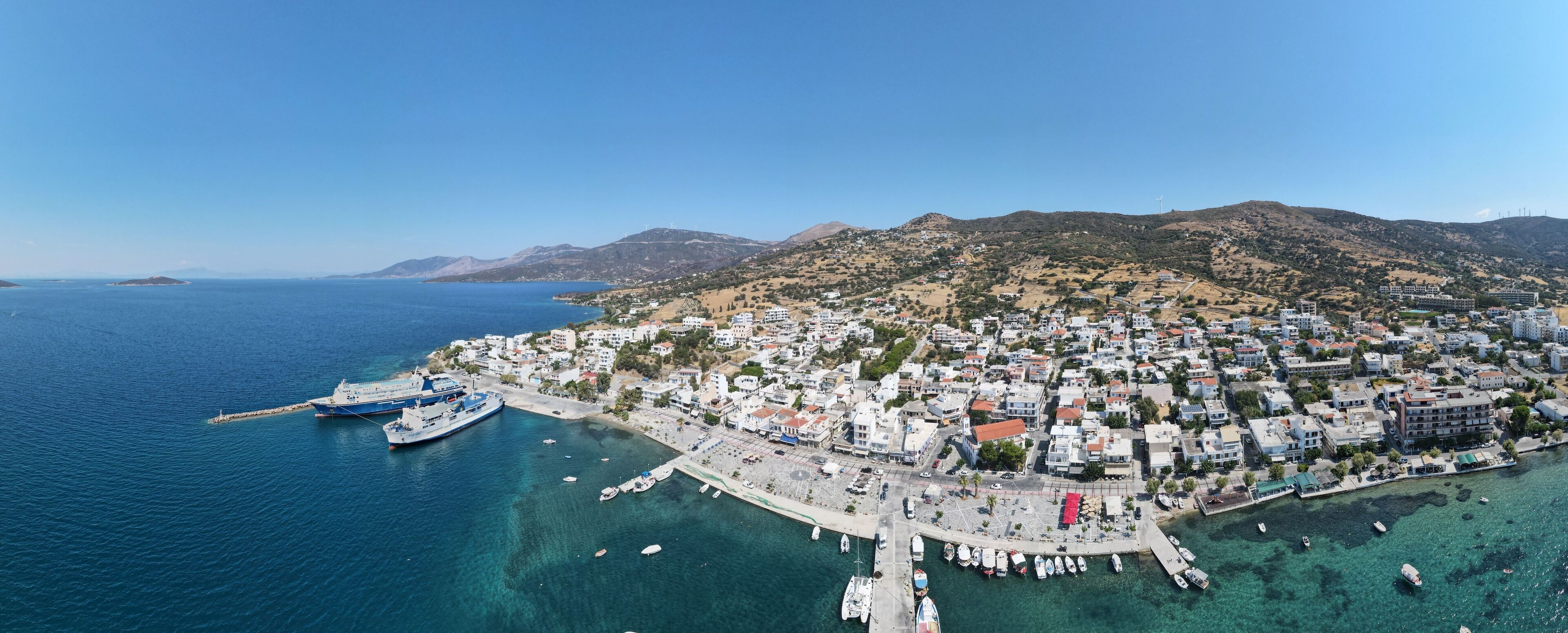 A coastal town with a marina, boats, and buildings.