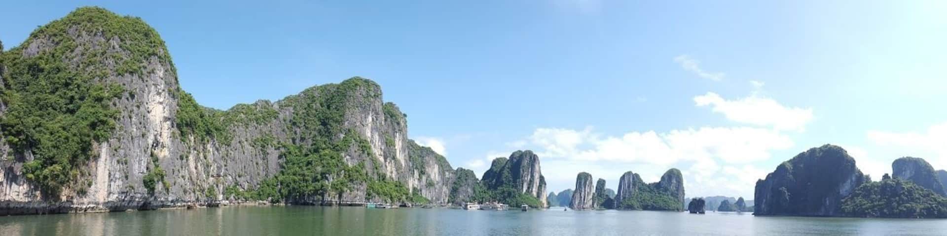 A coastal landscape with limestone karst formations and a calm sea.