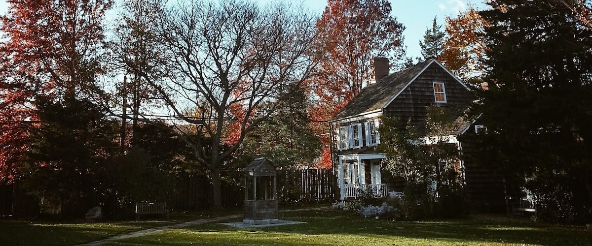 A house surrounded by trees with autumn leaves.