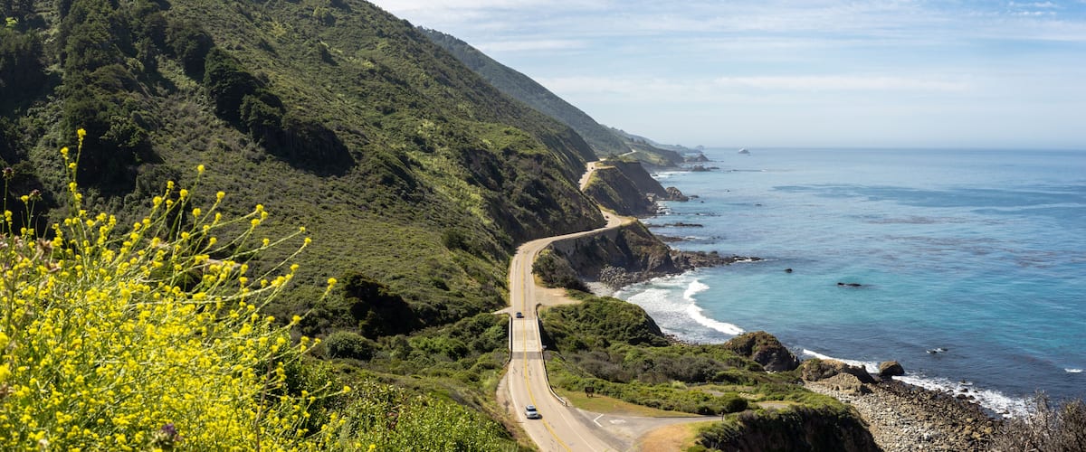 Una carretera costanera serpegen per un paisatge montaños amb vistes a l'oceà.