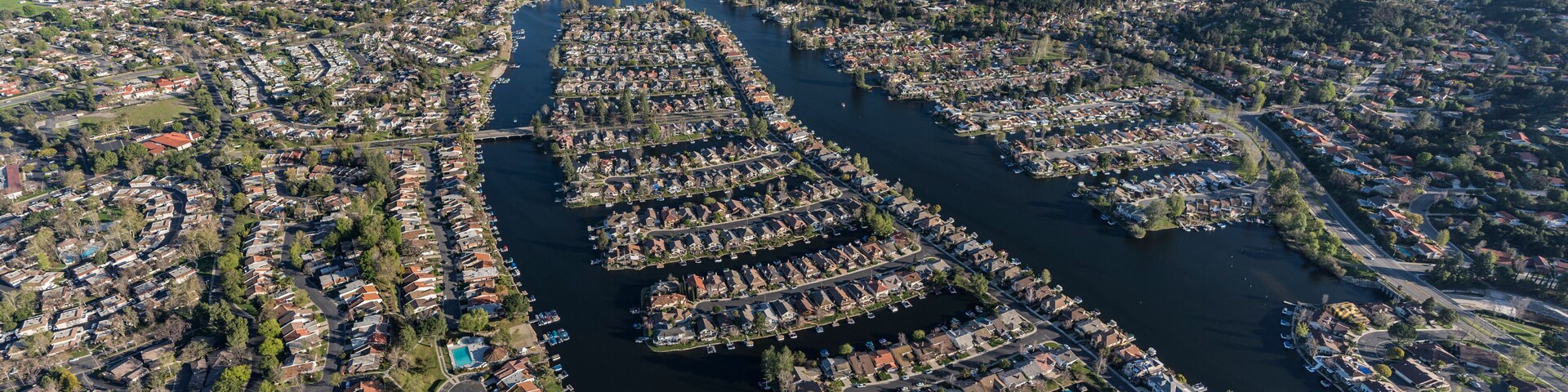 Vista aérea de un pueblo a orillas de un río, con zonas residenciales y muelles.