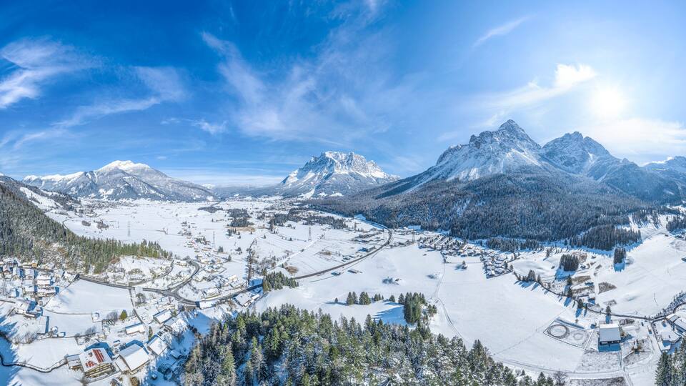 A snow-covered mountain town with ski slopes and buildings.