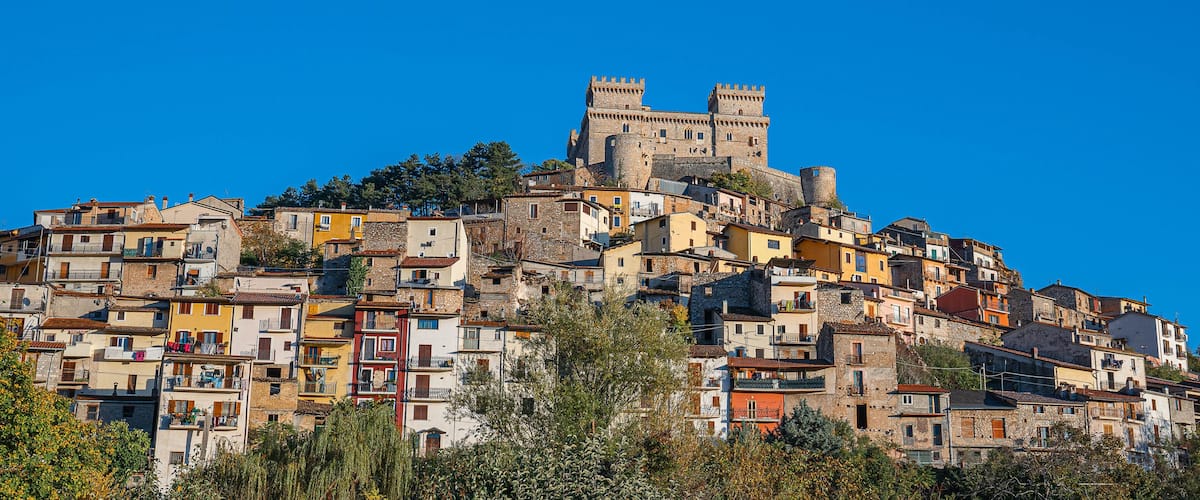 A historic hilltop town with colorful buildings and a prominent castle.