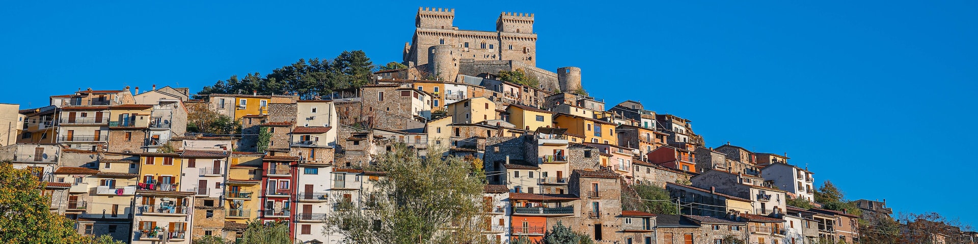 A historic hilltop town with colorful buildings and a prominent castle.