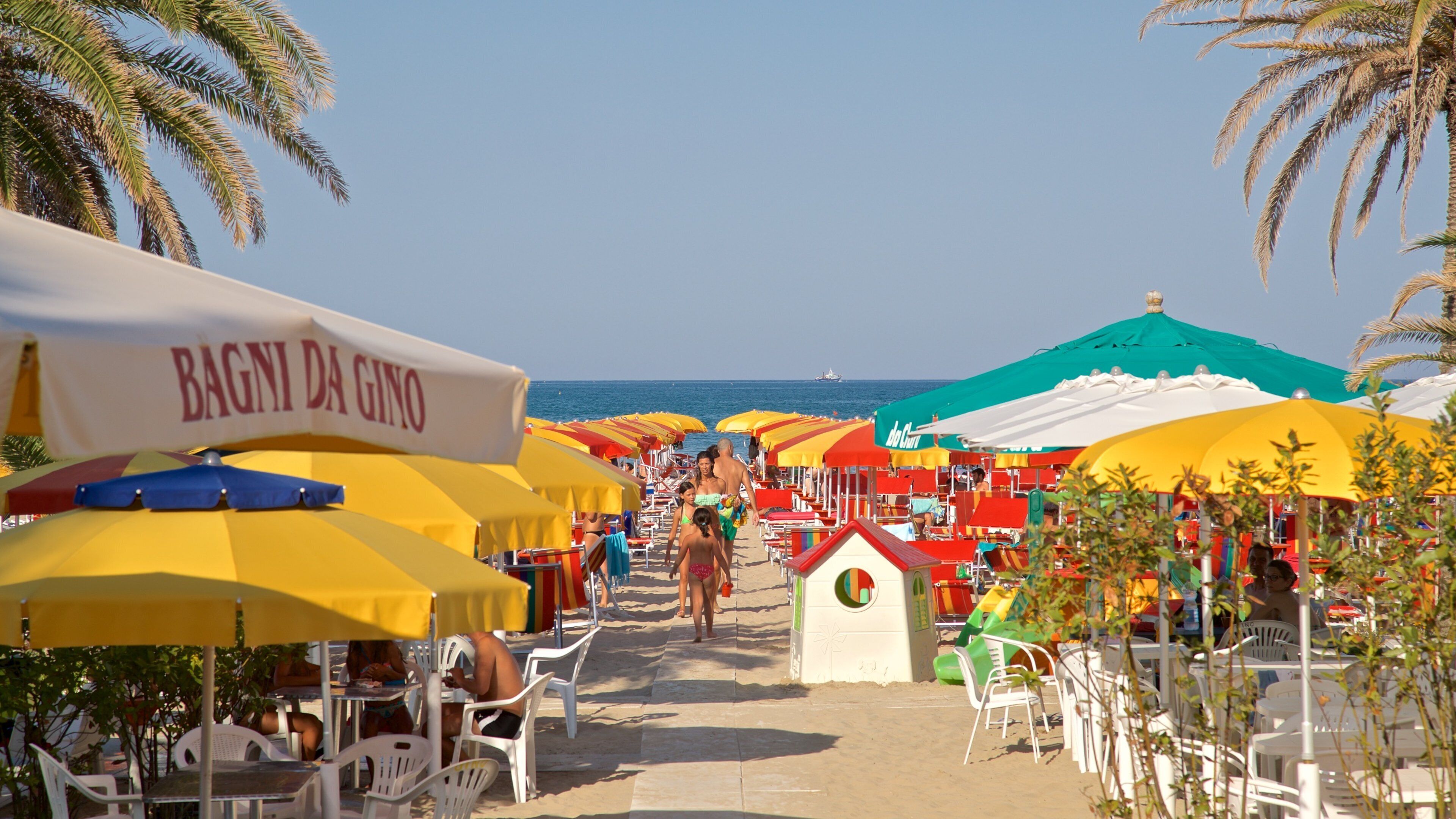 A beachside café with colorful umbrellas and outdoor seating.