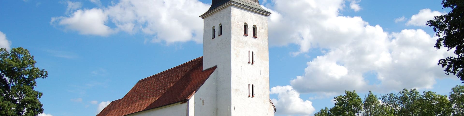 A church with a tall tower and a red roof.