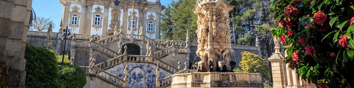 Ein historisches Gebäude mit aufwendiger Architektur, einer markanten Statue und einer schmucken Treppe.