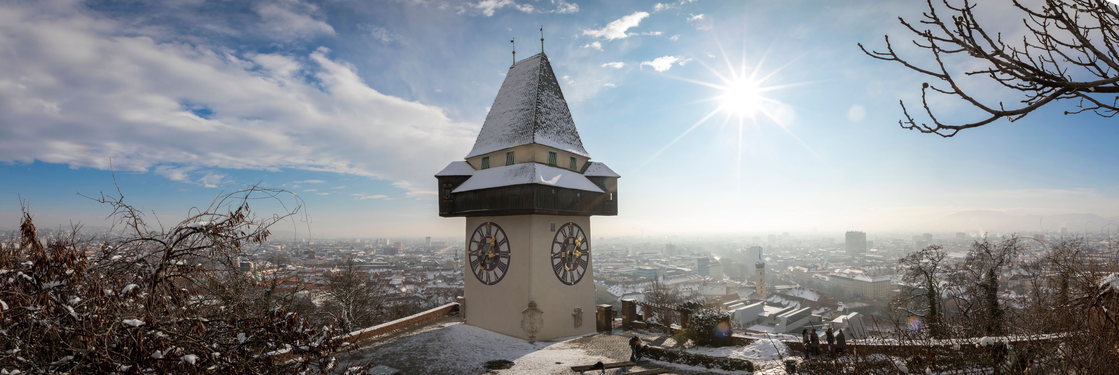 panorama of the  schlossberg hill with the landmark clocktower uhrturm in winter, graz, austria