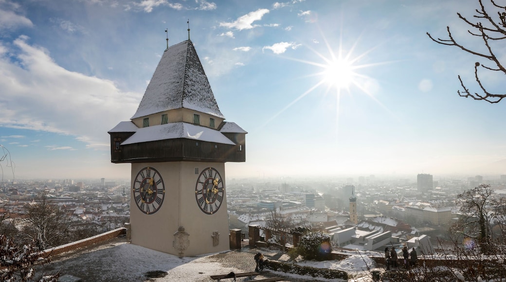 panorama of the schlossberg hill with the landmark clocktower uhrturm in winter, graz, austria