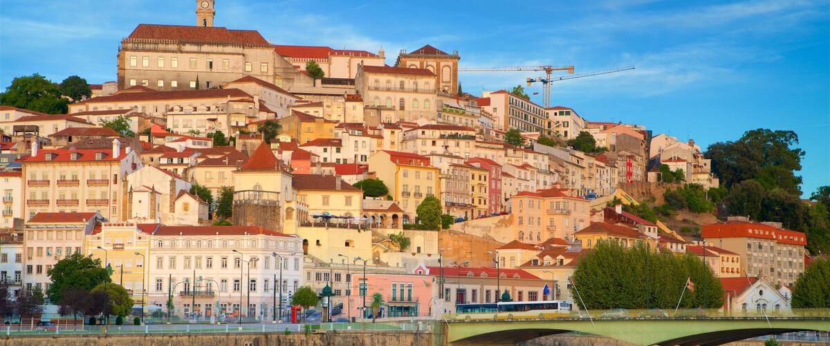 Un paisaje urbano histórico con un río, un puente y una mezcla de edificios coloridos.