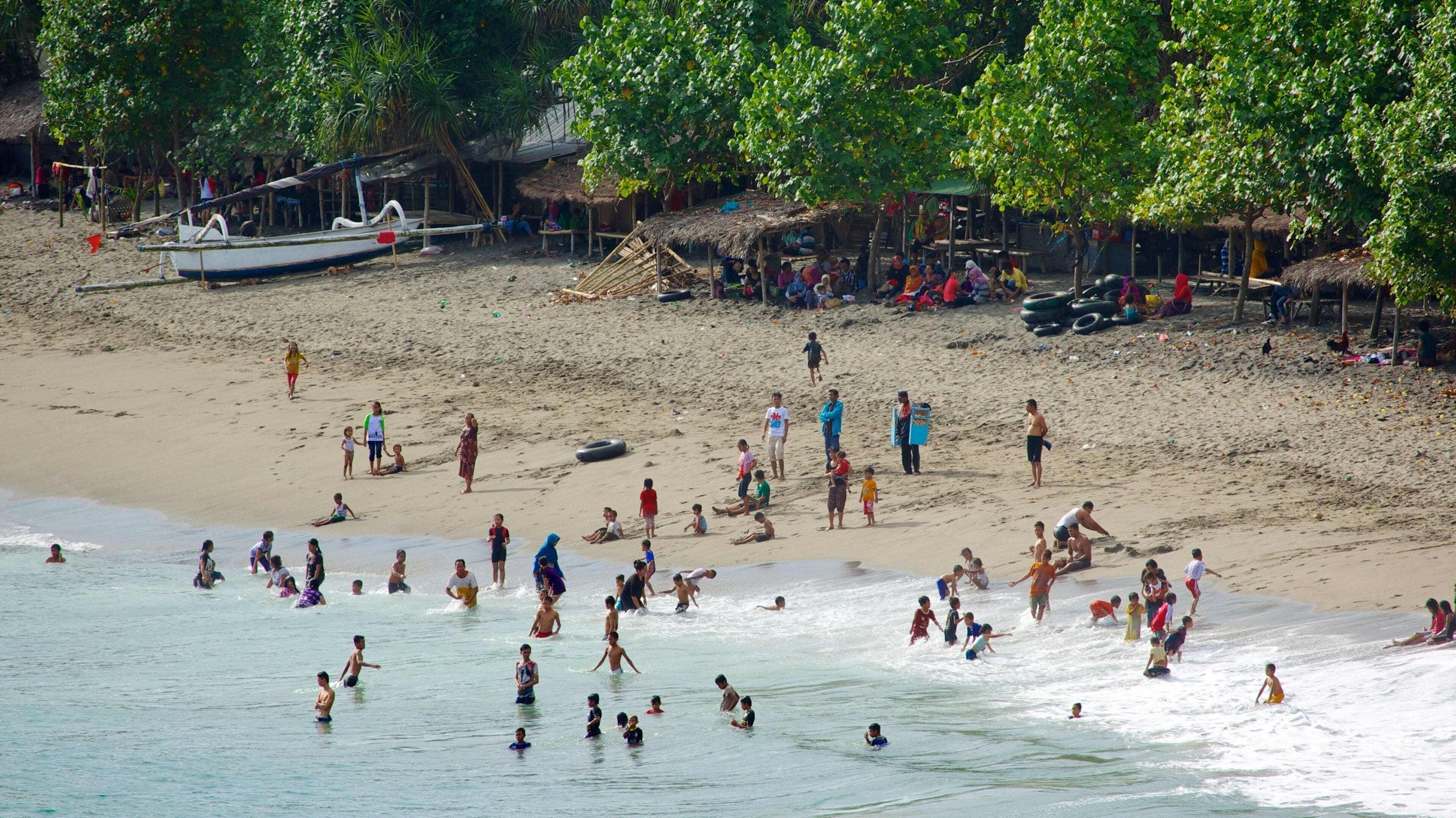 Senggigi showing a sandy beach, swimming and a small town or village