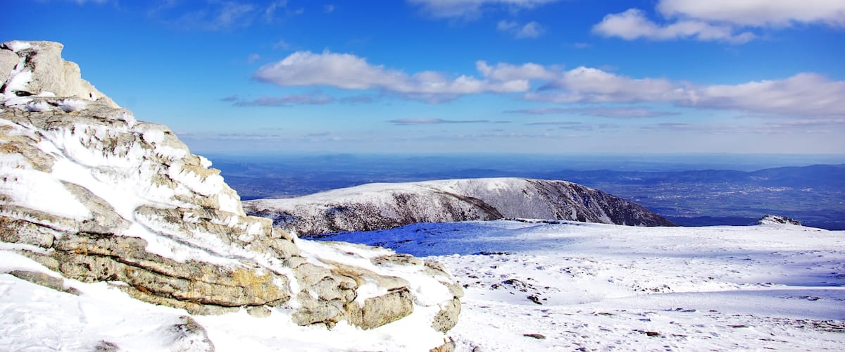 A snow-covered mountain range with a clear blue sky.