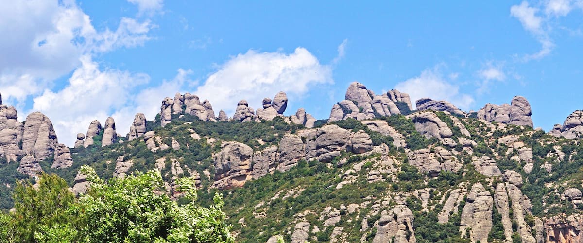 A rugged mountain range with prominent rock formations and sparse vegetation.