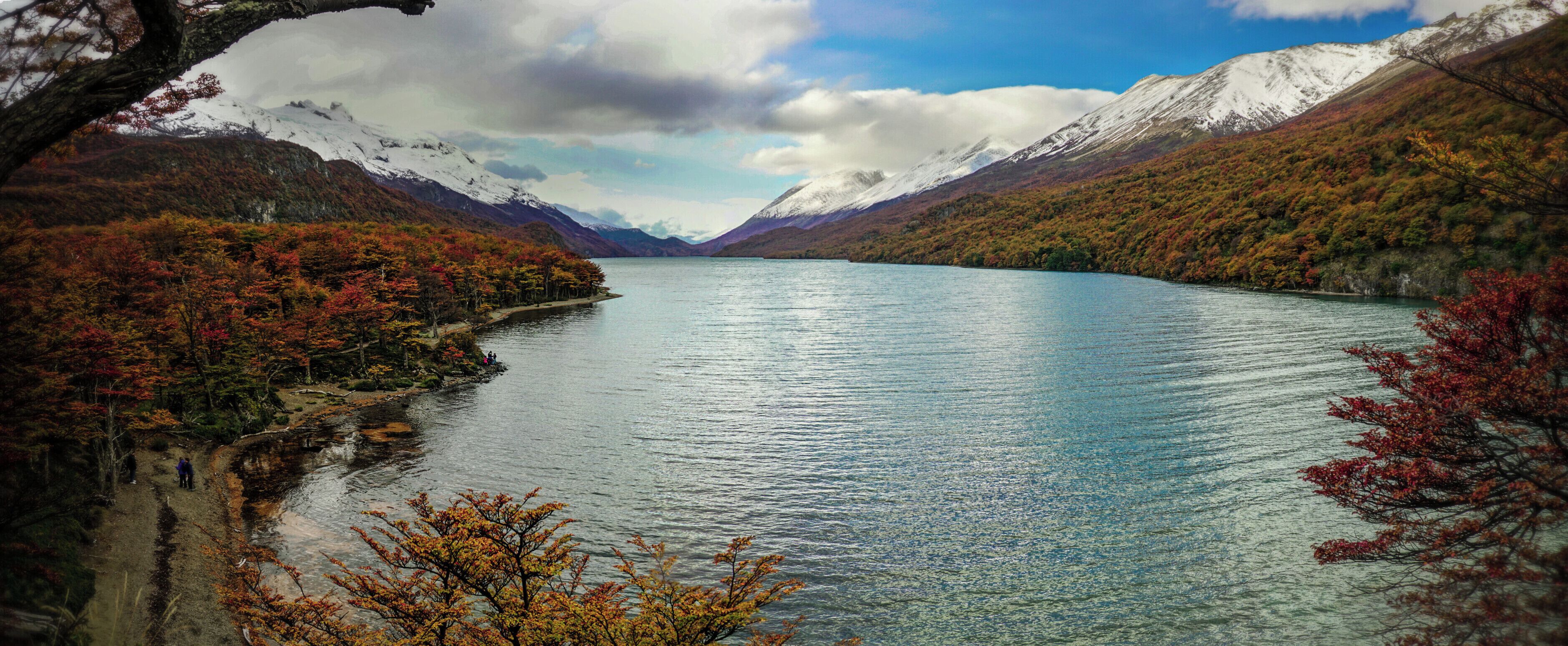 Un lago rodeado de montañas con follaje otoñal.
