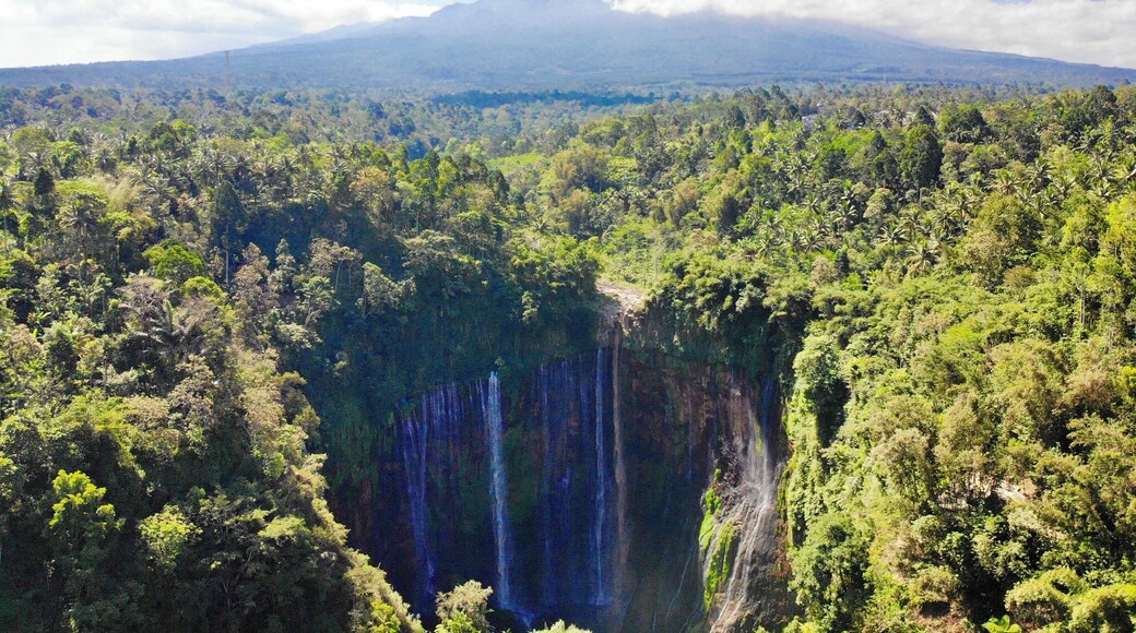 Drone shot where you can see the waterfall with Semeru Volcano behind