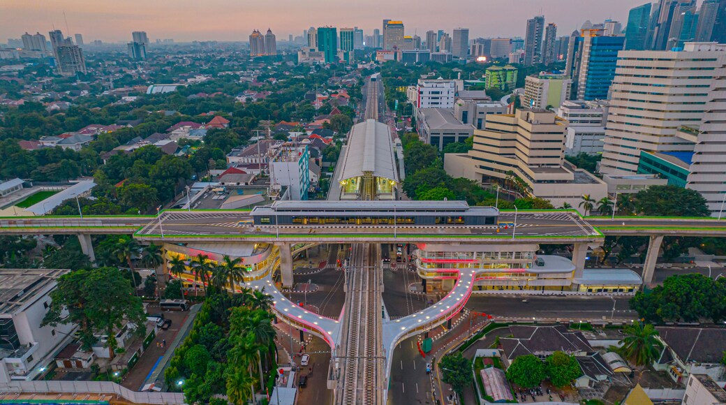 Aerial view of articulated city buses arriving and leaving at bus station near main railway station MRT line at Kebayoran Baru. Jakarta, Indonesia, July 29, 2021