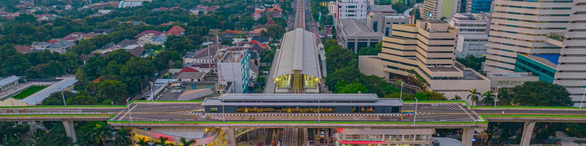Aerial view of articulated city buses arriving and leaving at bus station near main railway station MRT line at Kebayoran Baru. Jakarta, Indonesia, July 29, 2021