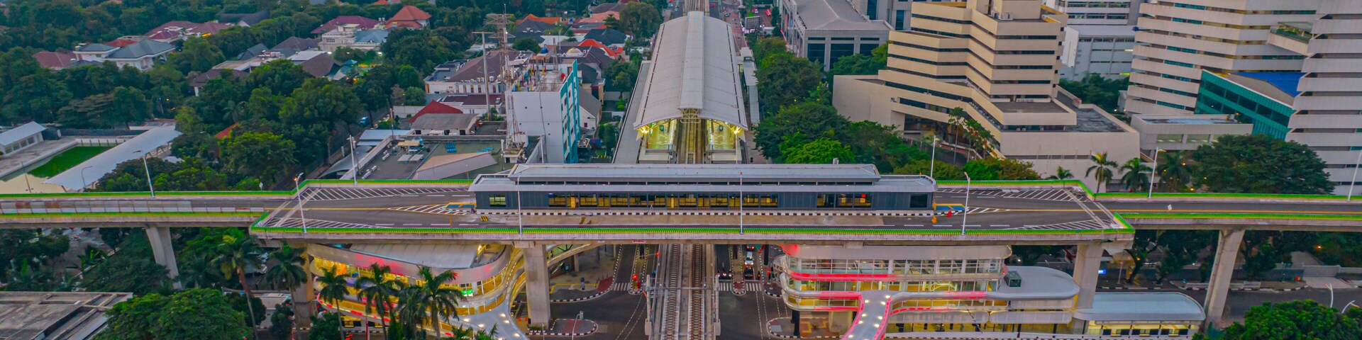 Aerial view of articulated city buses arriving and leaving at bus station near main railway station MRT line at Kebayoran Baru. Jakarta, Indonesia, July 29, 2021