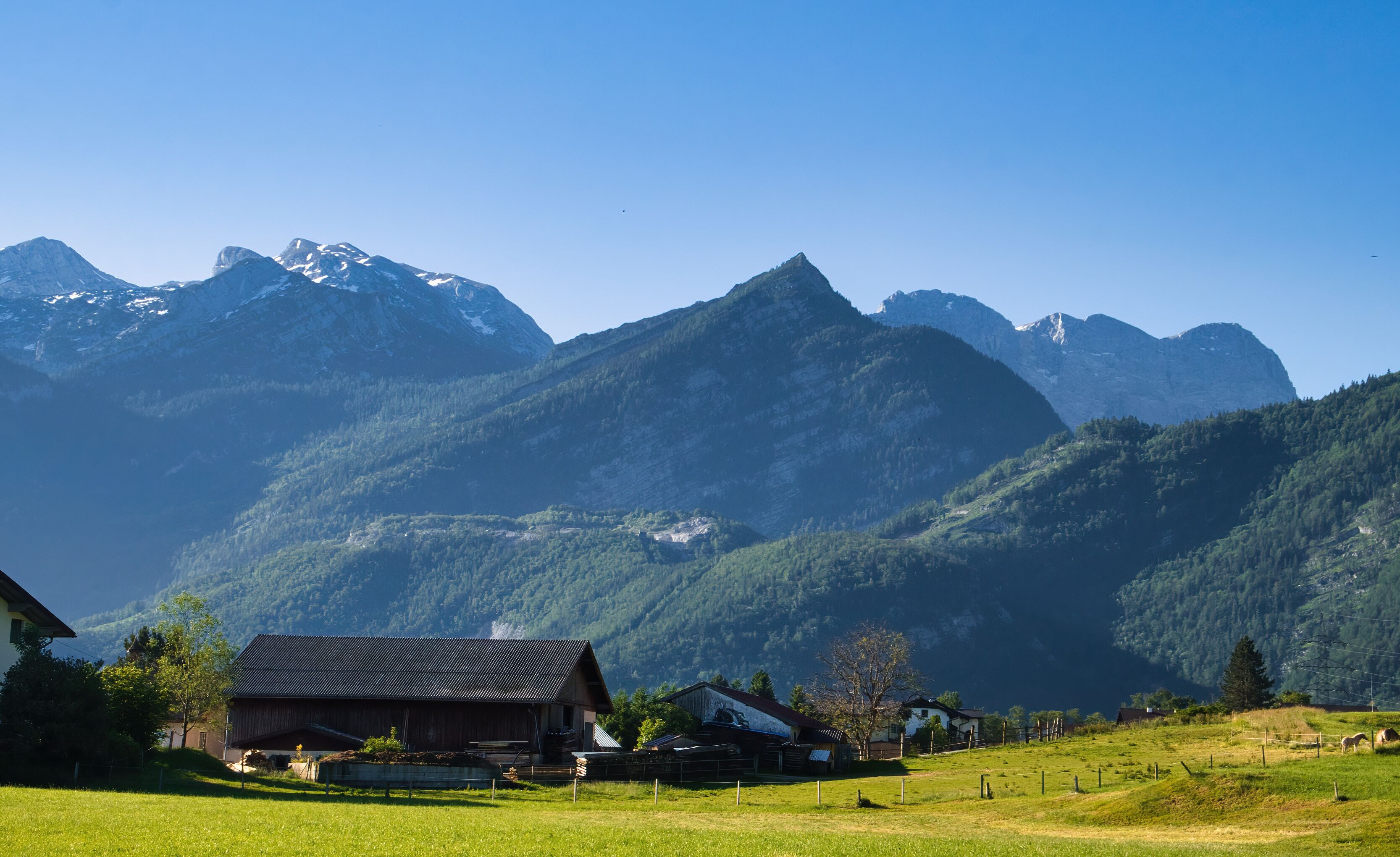 Sun shining on mountains behind houses in Golling an der Salzach, Austria on a spring morning.