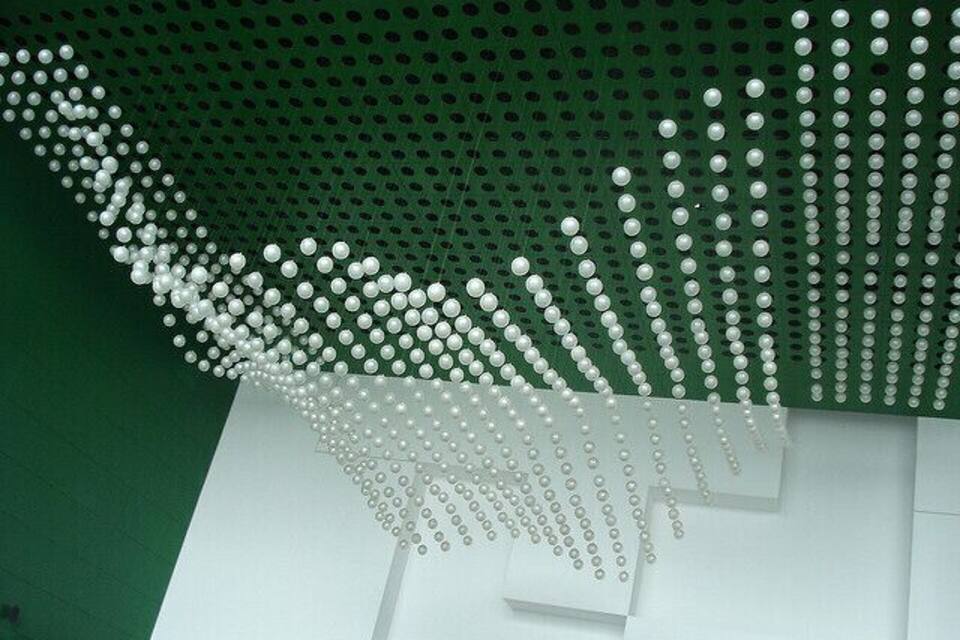 Un plafond orné d’un motif de petites sphères lumineuses blanches sur un fond vert.