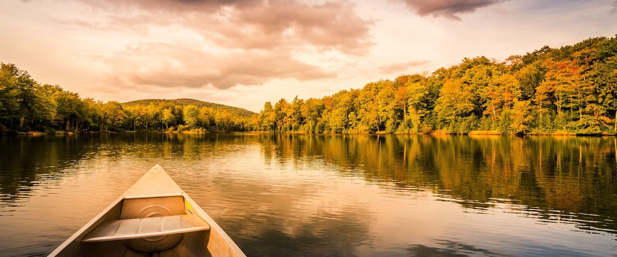 Aluminum canoe on a mountain lake upstate New York. Camping. outdoors and adventure concept. Faded, vintage color post processed