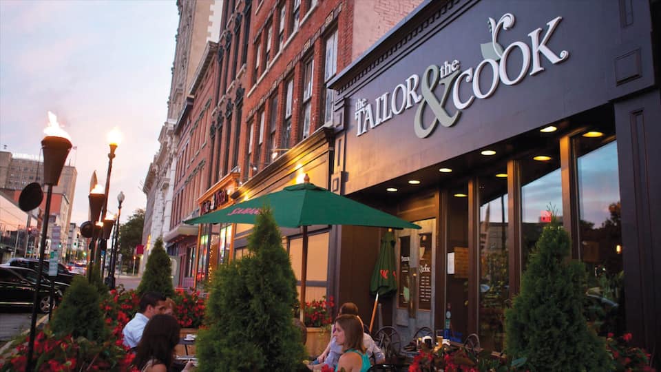 A restaurant named 'The Tailor & Cook' with outdoor seating and a green awning.