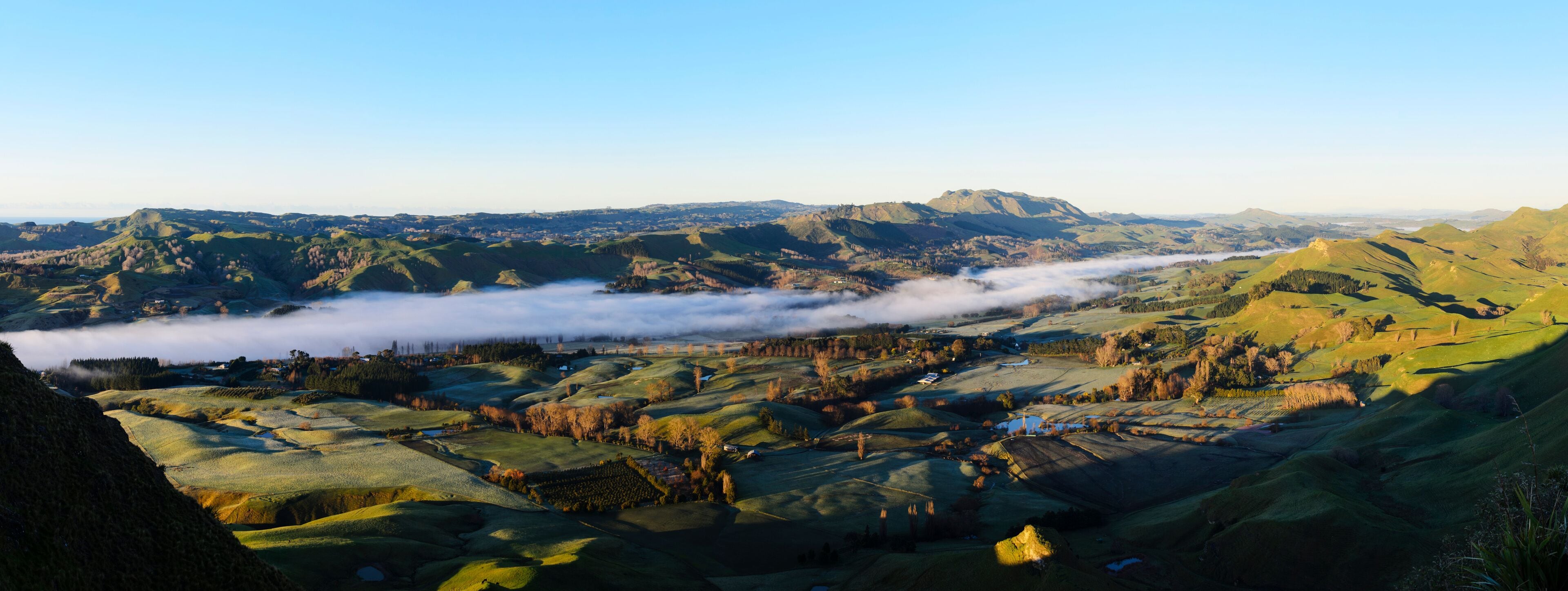 Rolling hills, a valley, and a distant mountain range.