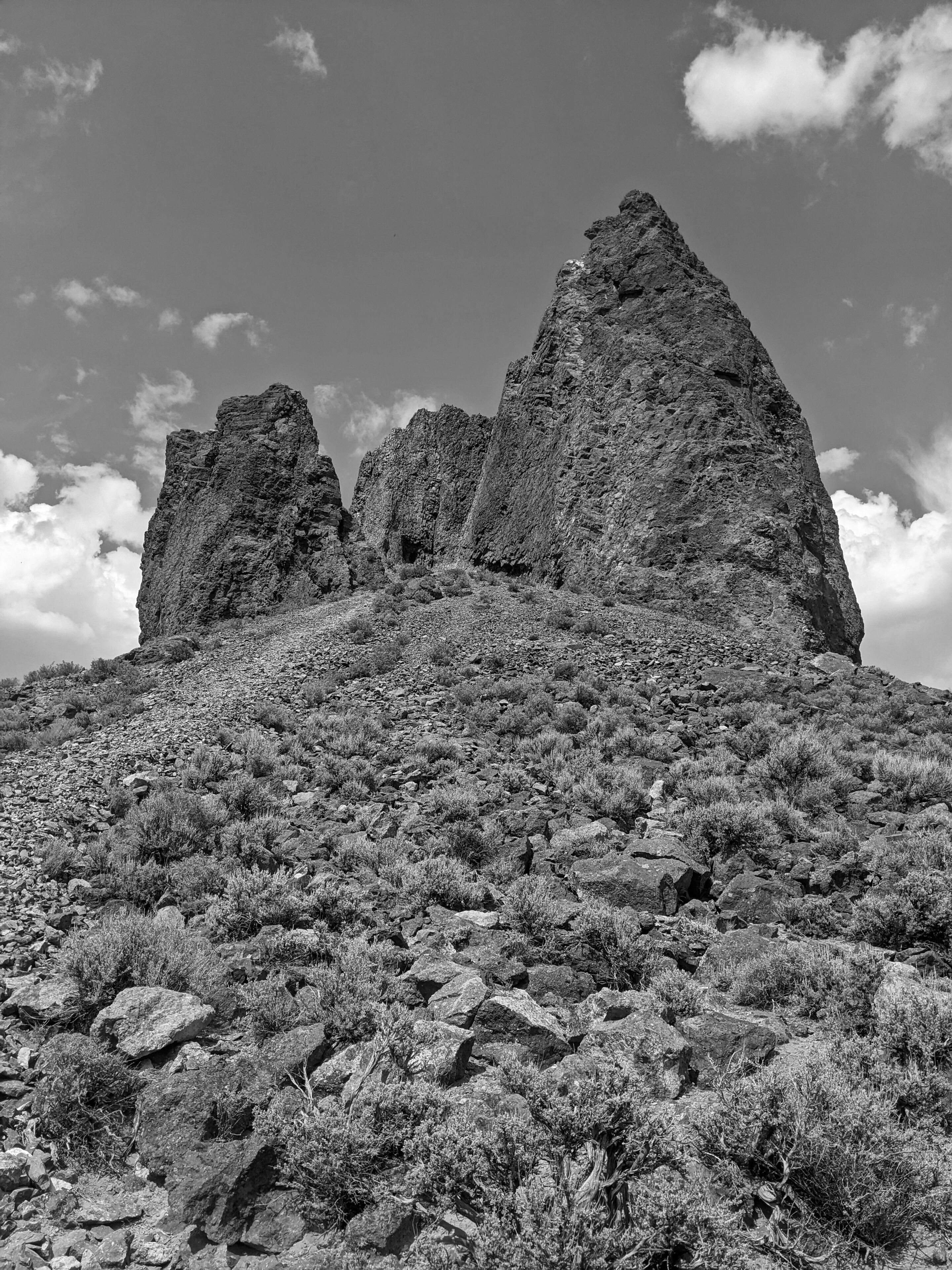 A rugged mountain landscape with prominent rock formations and sparse vegetation.