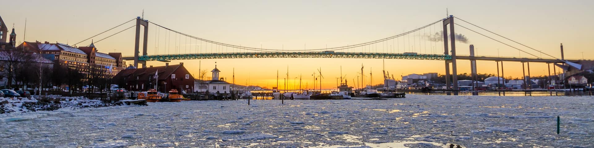 Gothenburg - Beautiful sunset at frozen Gota river with Hisingsleden Bridge in the harbor district during winter