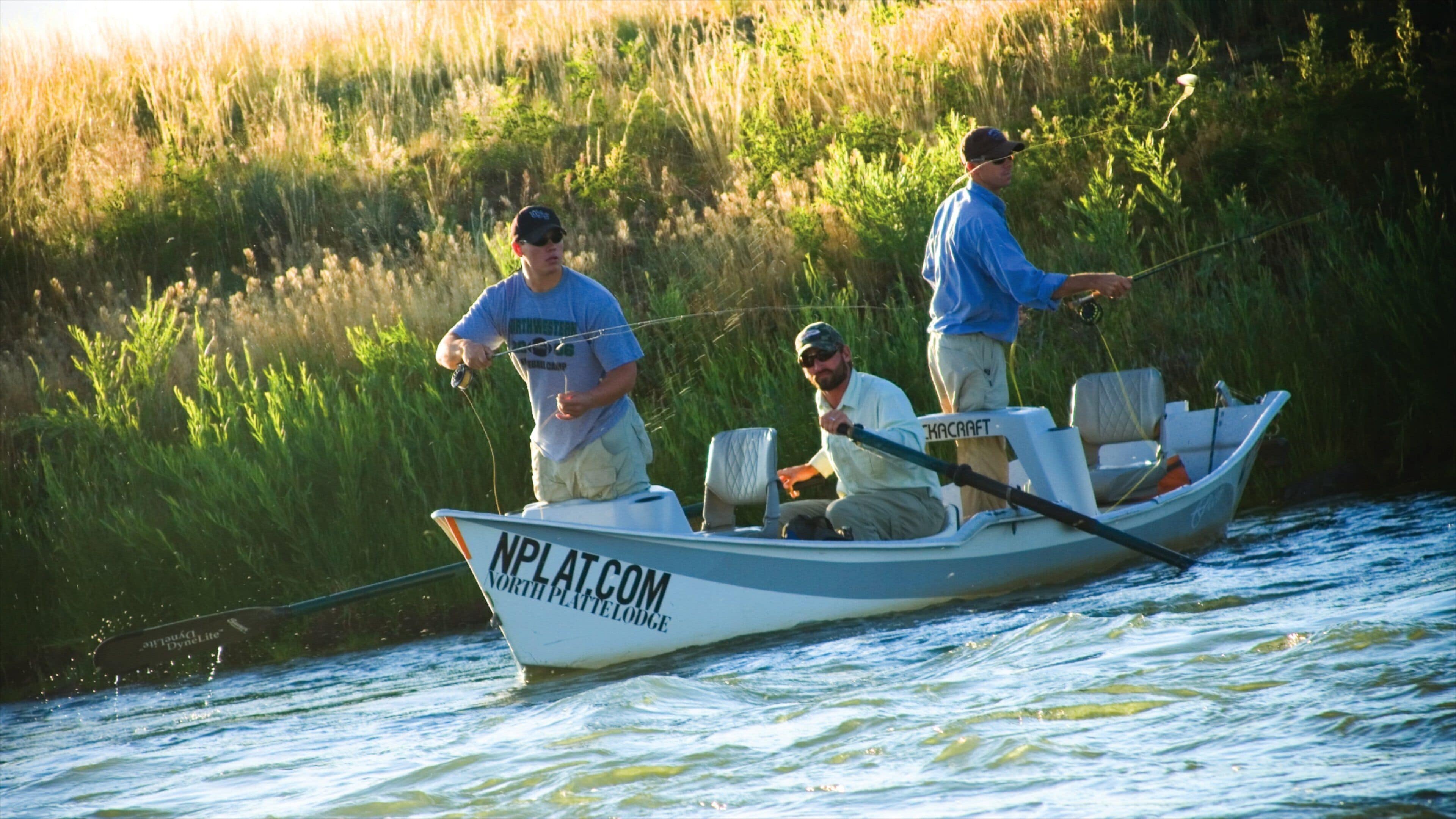 A small boat on a river with people fishing.