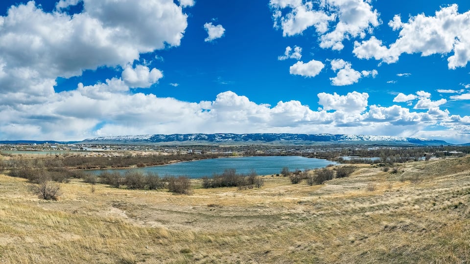 A lake surrounded by mountains and a town.