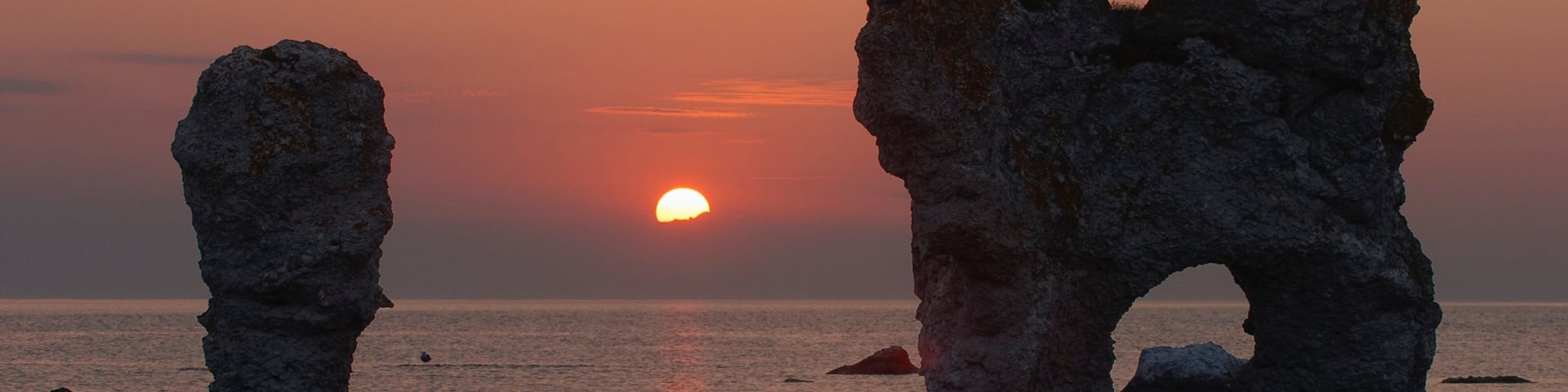 Gotland County which includes a sunset, a sandy beach and rocky coastline