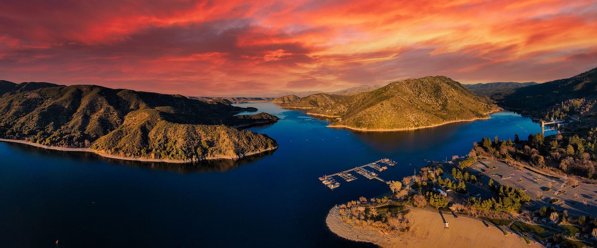 A mountainous landscape with a large lake, a small island, and a marina.