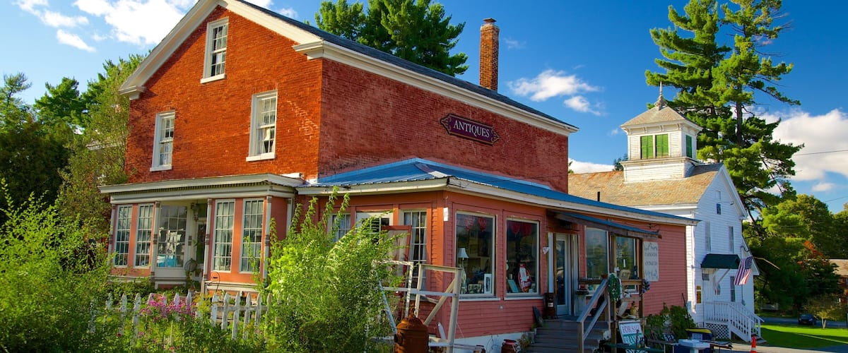 A red brick building with a sign reading "Antiques" and a small white tower with a green roof.