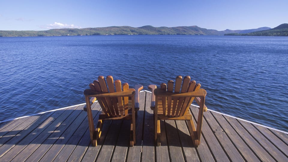 Two Adirondack chairs on a deck overlooking Lake George, NY