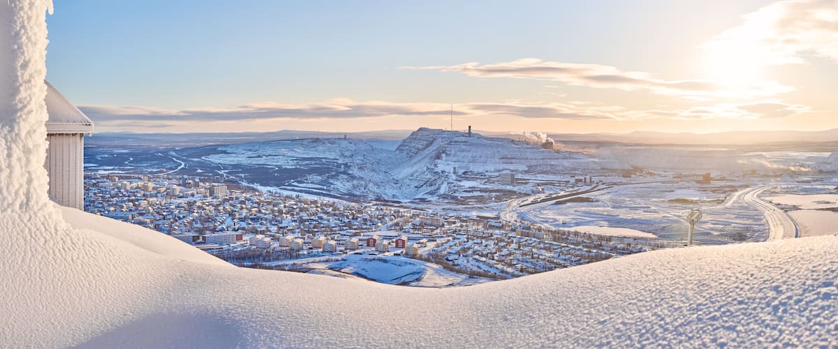 A snow-covered town with a prominent hill and a tower.