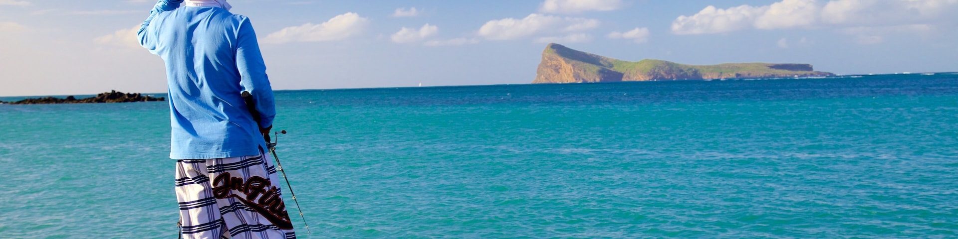 Cap Malheureux mostrando litoral accidentado y también un hombre