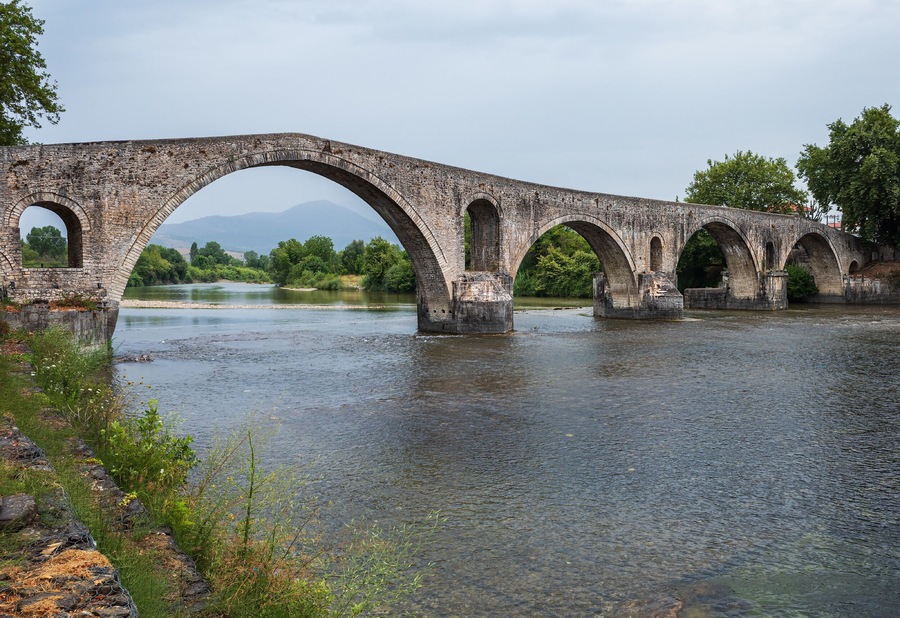 Arta Bridge - A bridge over the Arachos River in the city of Arta. The construction of the bridge dates back to the era of Despotat, but the current appearance by 1602.
According to legend, every day 60 students and 45 craftsmen under the guidance of the chief builder tried to build a bridge, but it fell every night. Finally, a bird with a human voice told the chief builder that in order for the bridge to stand, he had to sacrifice his spouse. When the wife was walled up, she first cursed, but then finished with blessings.