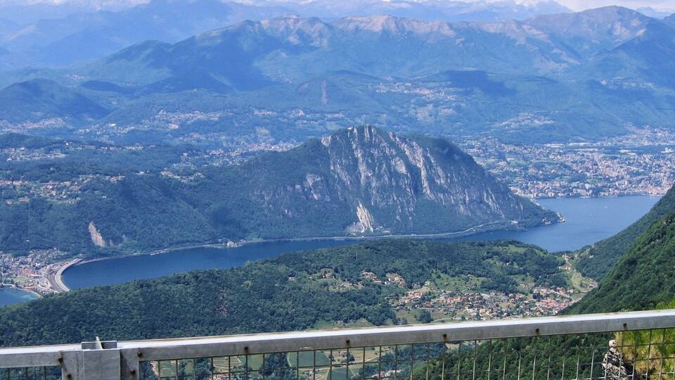A mountainous landscape with a prominent peak, a lake, and a town below.