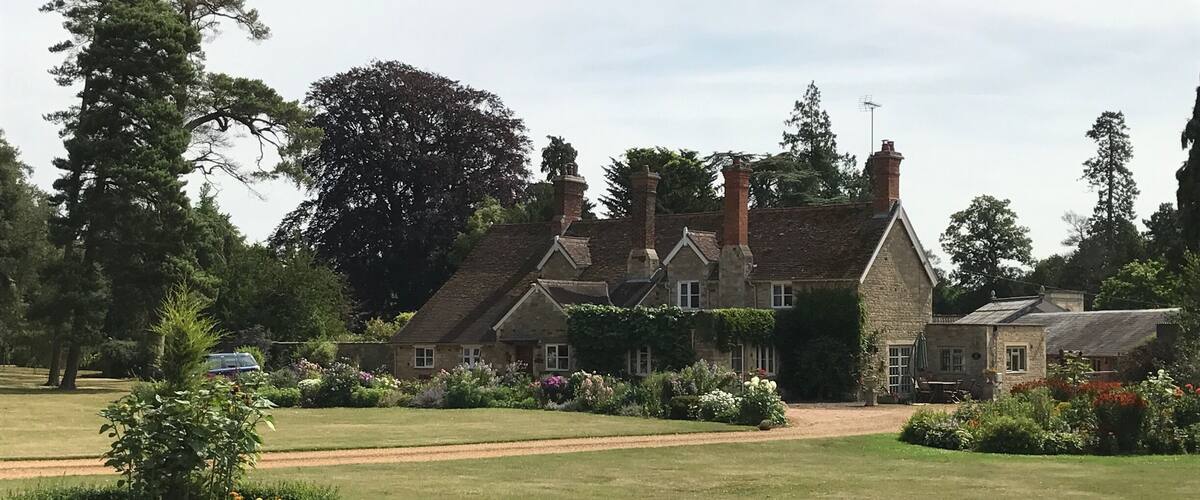 A large stone house with a garden in front.
