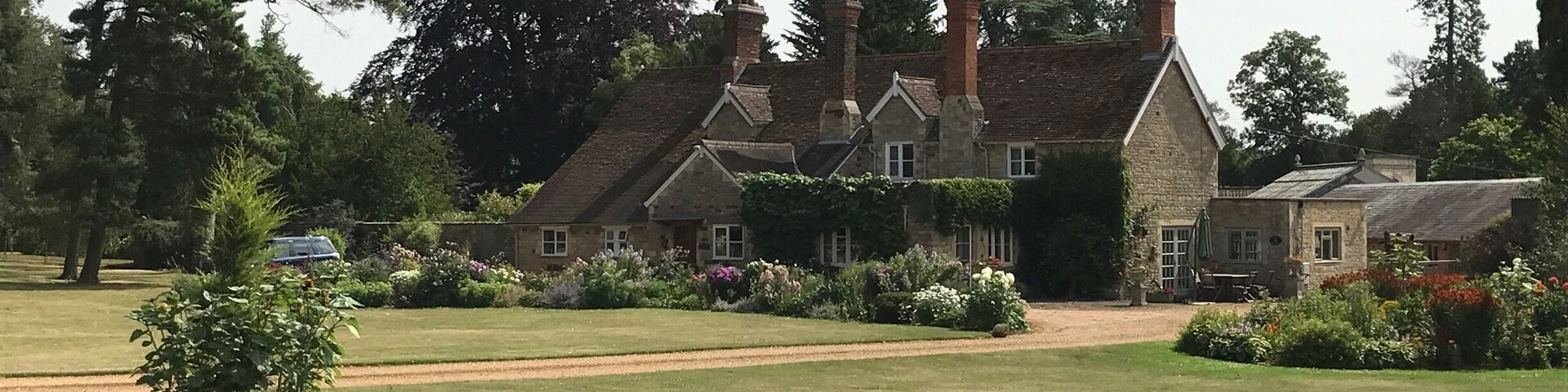 A large stone house with a garden in front.