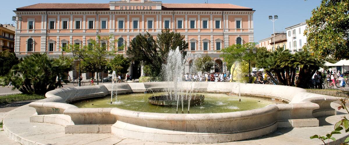 A historic building with a fountain in front.