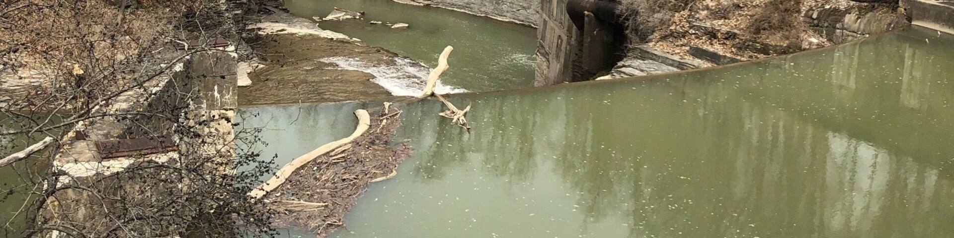 A river with a bridge and a stone structure.