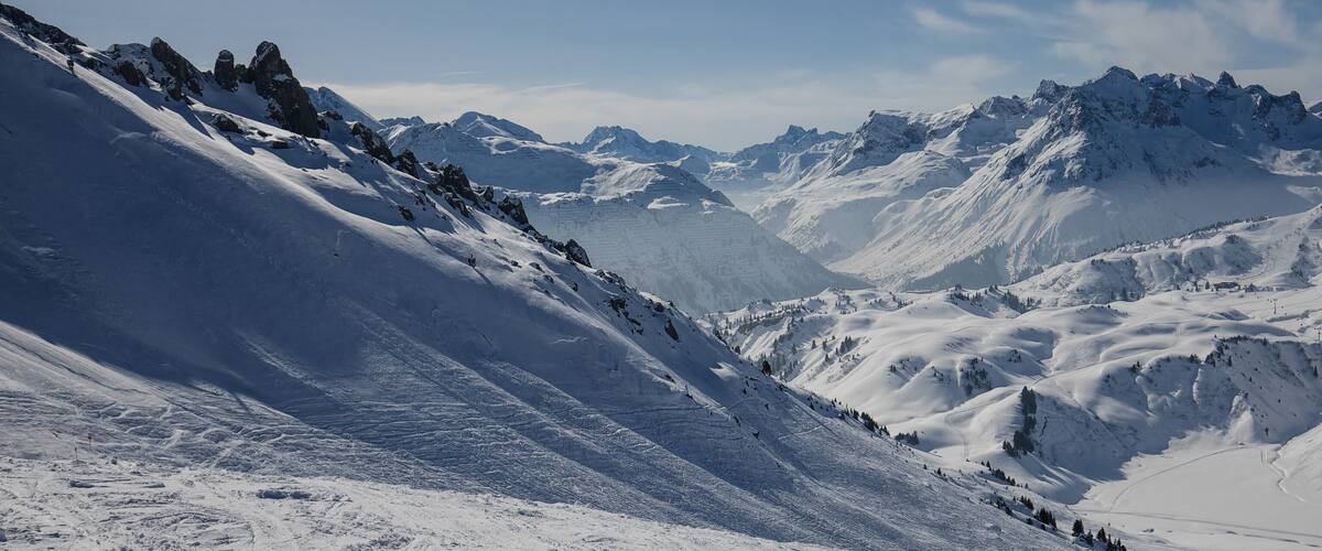 A snow-covered mountain range with sharp peaks and deep valleys.