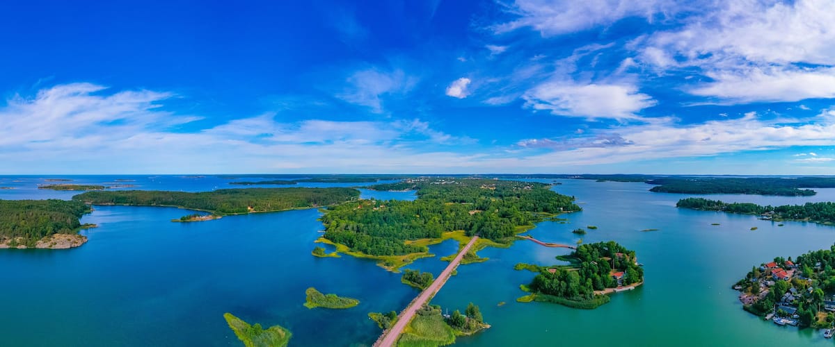 An aerial view of a lake surrounded by forested islands and a bridge.