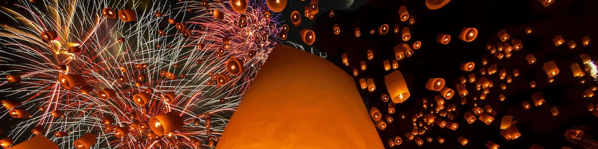 A night sky filled with lanterns and fireworks.