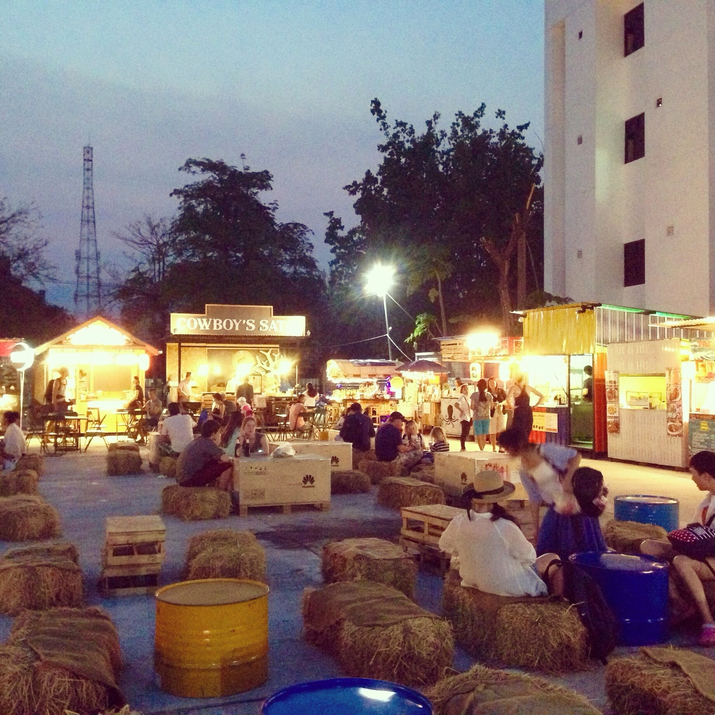 Near the intersection of Cha Roen Prathar  and Thapae road (night bazaar) sits a square of food carts with a great selection of international foods. 
Sit on hay bails, enjoy the indie soundtrack pipping through the sound system and take your choice of gyoza, pizza, Japanese curry, satay, and hamburgers to name just a few. There's even a beer bar for those so inclined. 
Bring cash as plastic isn't accepted. Moto parking out back is 10baht.