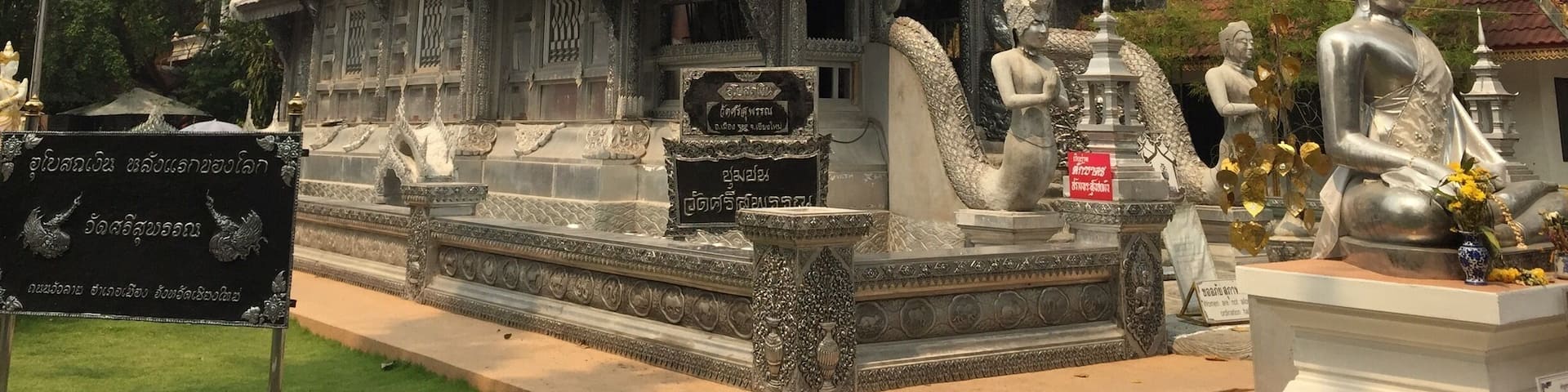 A traditional Thai temple with ornate architecture, including a multi-tiered roof and intricate carvings.