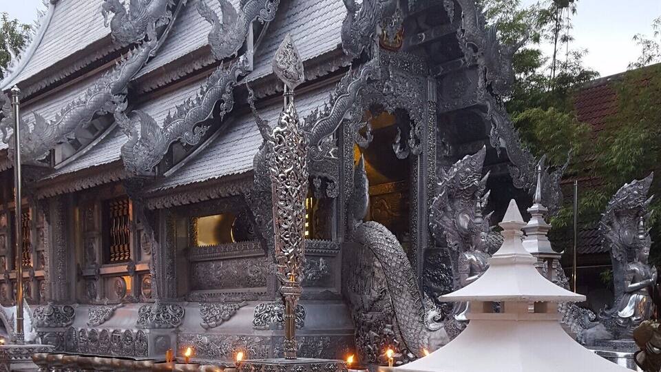 A traditional temple with ornate dragon carvings and a lotus pond with floating flowers.